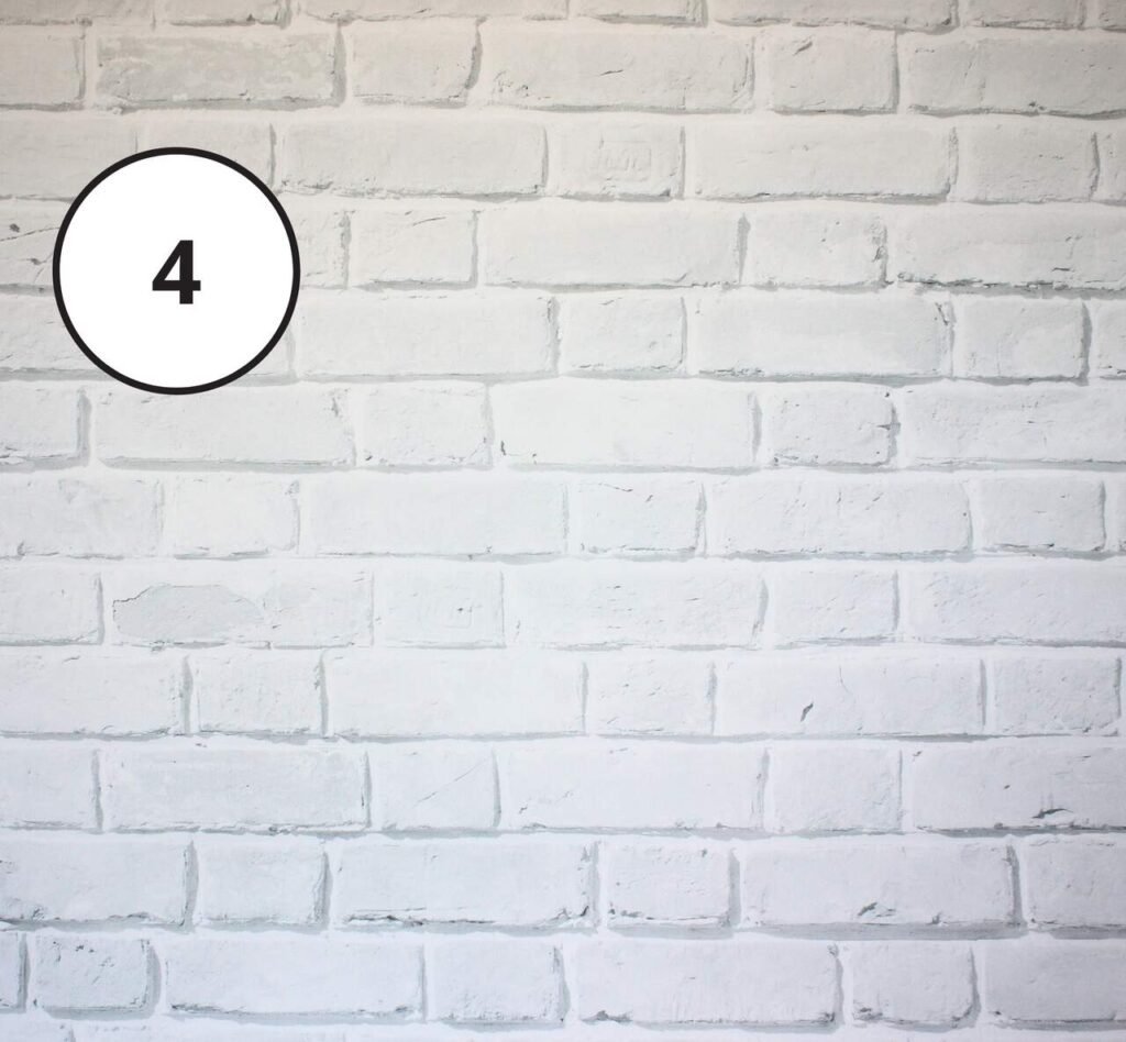 Drewniana fotobudka z tłem z białej cegły – elegancka oprawa do zdjęć.